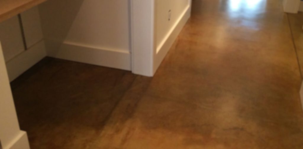 Acid-stained concrete overlay floor with warm brown tones in a California residential interior