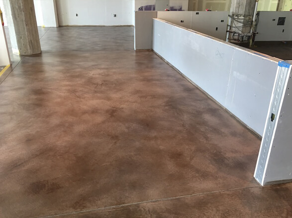 Smooth brown acid-stained concrete floor showing rich color variation in a North Bay California commercial interior