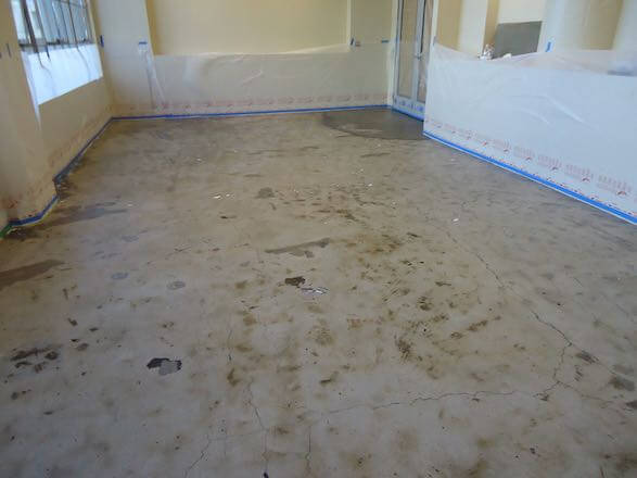 Cracked, stained concrete garage floor prepped for decorative overlay resurfacing in a North Bay California home