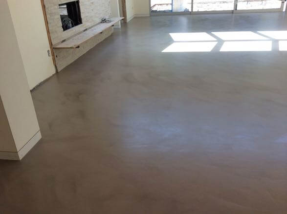 Smooth gray polymer modified overlay concrete floor in a Napa living room, showcasing finished resurfacing results in the North Bay CA area.