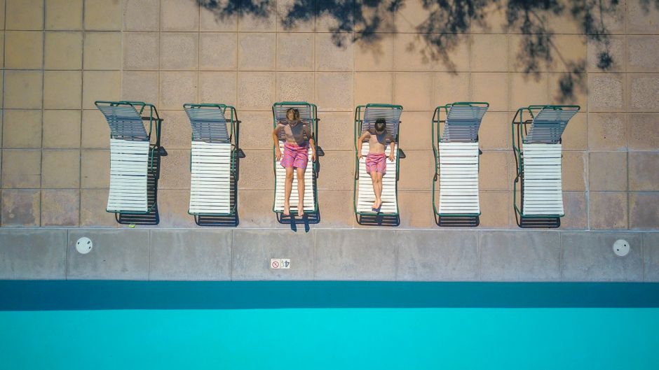 Aerial view of pool deck with concrete surround and sun loungers on a sunny Sonoma County summer day