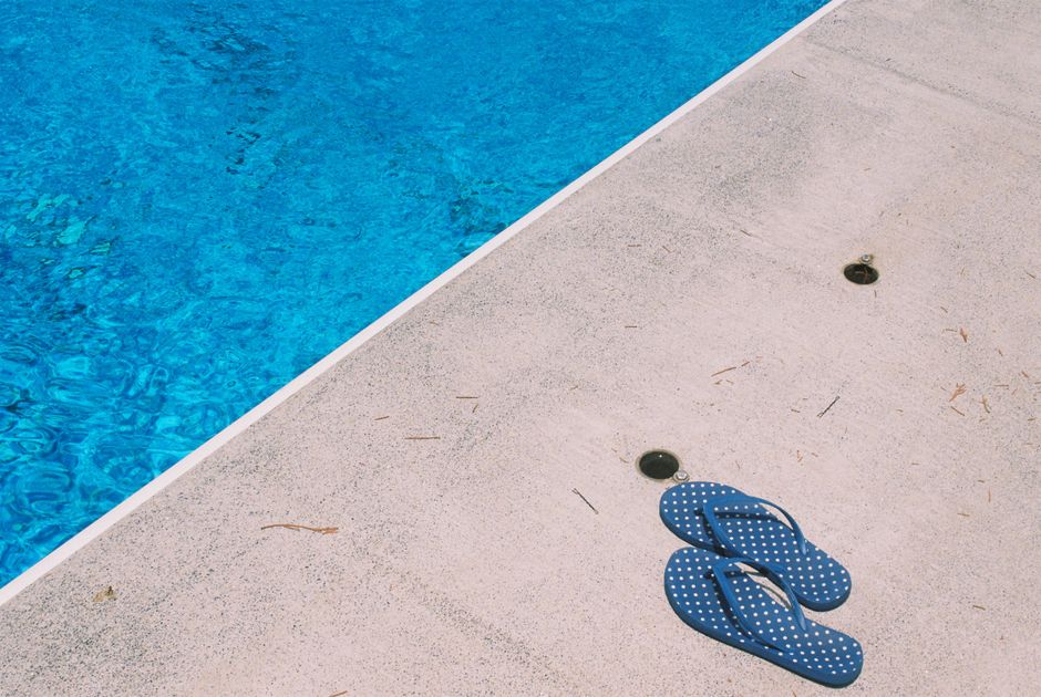 Worn concrete pool deck surface beside a backyard swimming pool in Sonoma County, showing texture ideal for overlay or coating