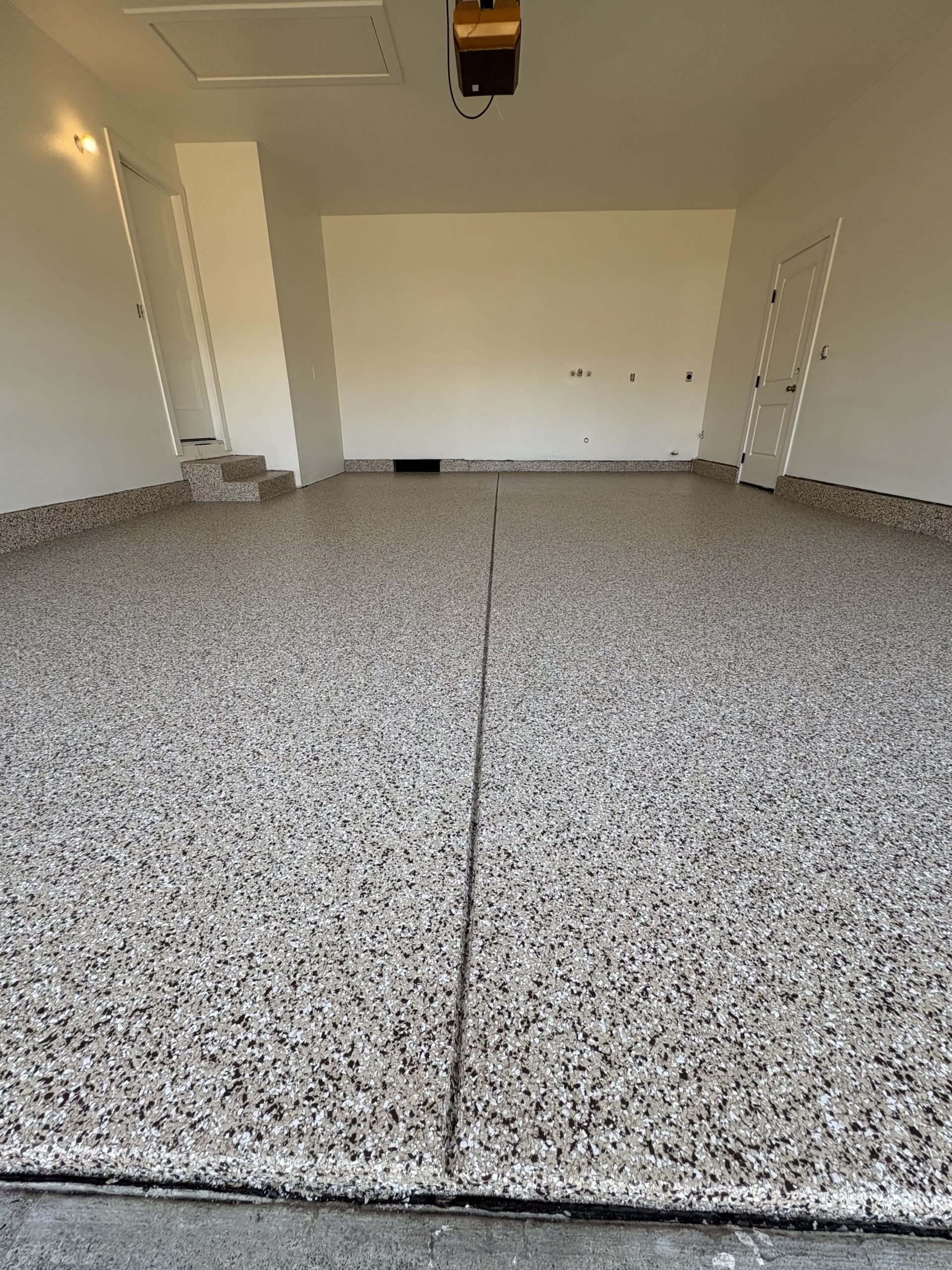 Gray and white vinyl chip epoxy garage floor coating on a two-car garage floor and steps in Fairfield, CA by J&C Concrete