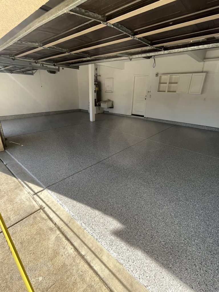 Dark gray vinyl chip epoxy flake floor in a freshly coated two-car garage in North Bay California