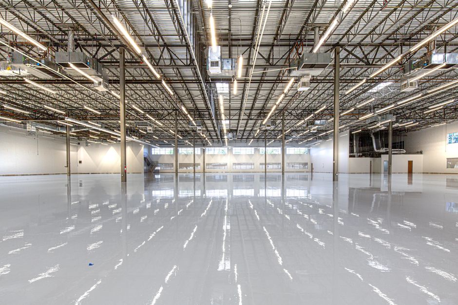 Glossy epoxy-coated concrete floor in a large commercial facility, showcasing durable flooring results similar to vinyl chip epoxy in the North Bay.