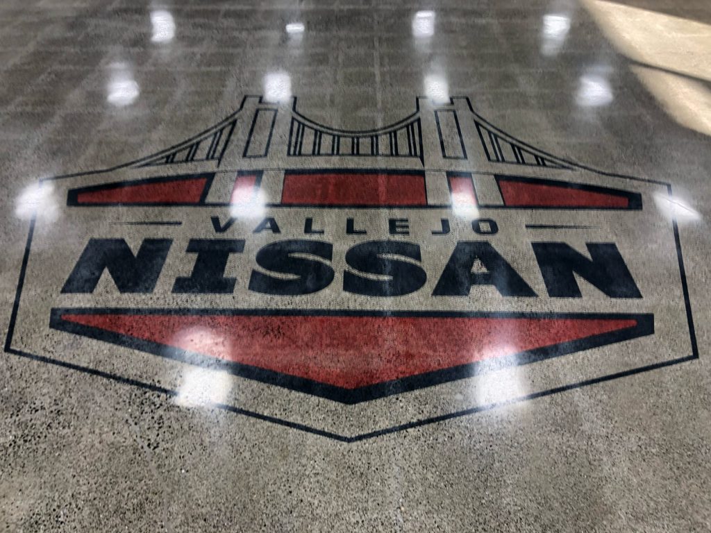 Vallejo Nissan logo embedded in polished concrete showroom floor, North Bay CA decorative concrete coating